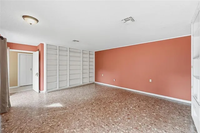 an empty room with closet and a ceiling fan