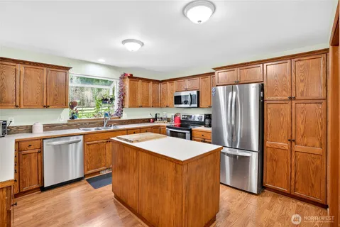 a kitchen with granite countertop stainless steel appliances a refrigerator a sink and cabinets