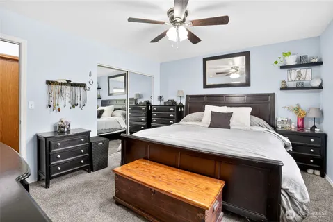 a bedroom with a bed and paintings on wall