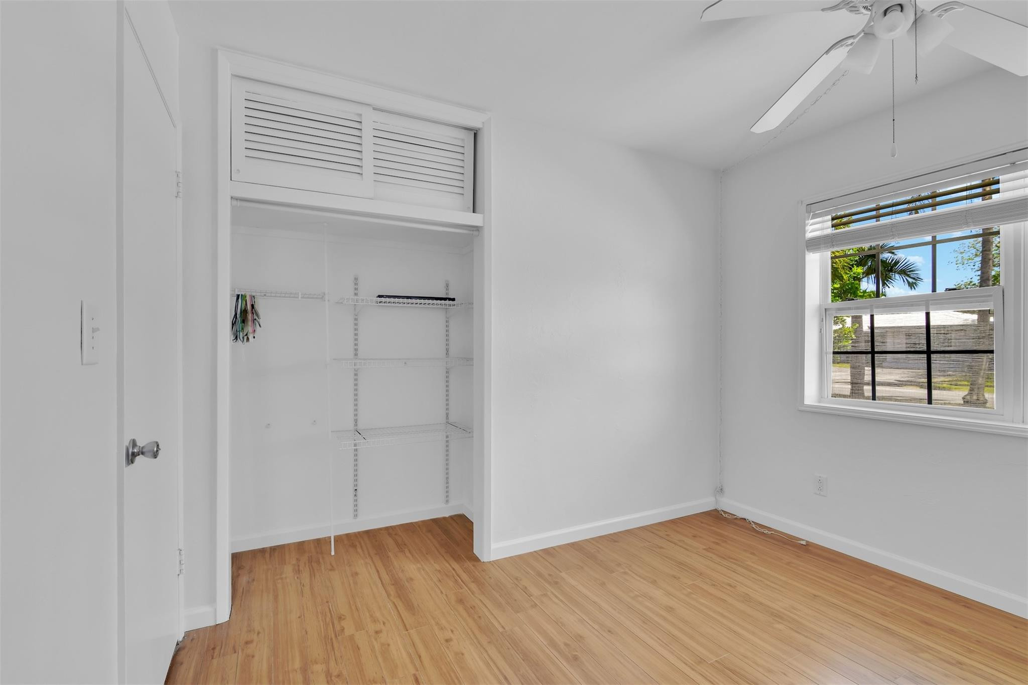 341 Southeast 8th Street Pompano Beach, FL 33060 - Photo 29 of 56 a view of an empty room with wooden floor and a window