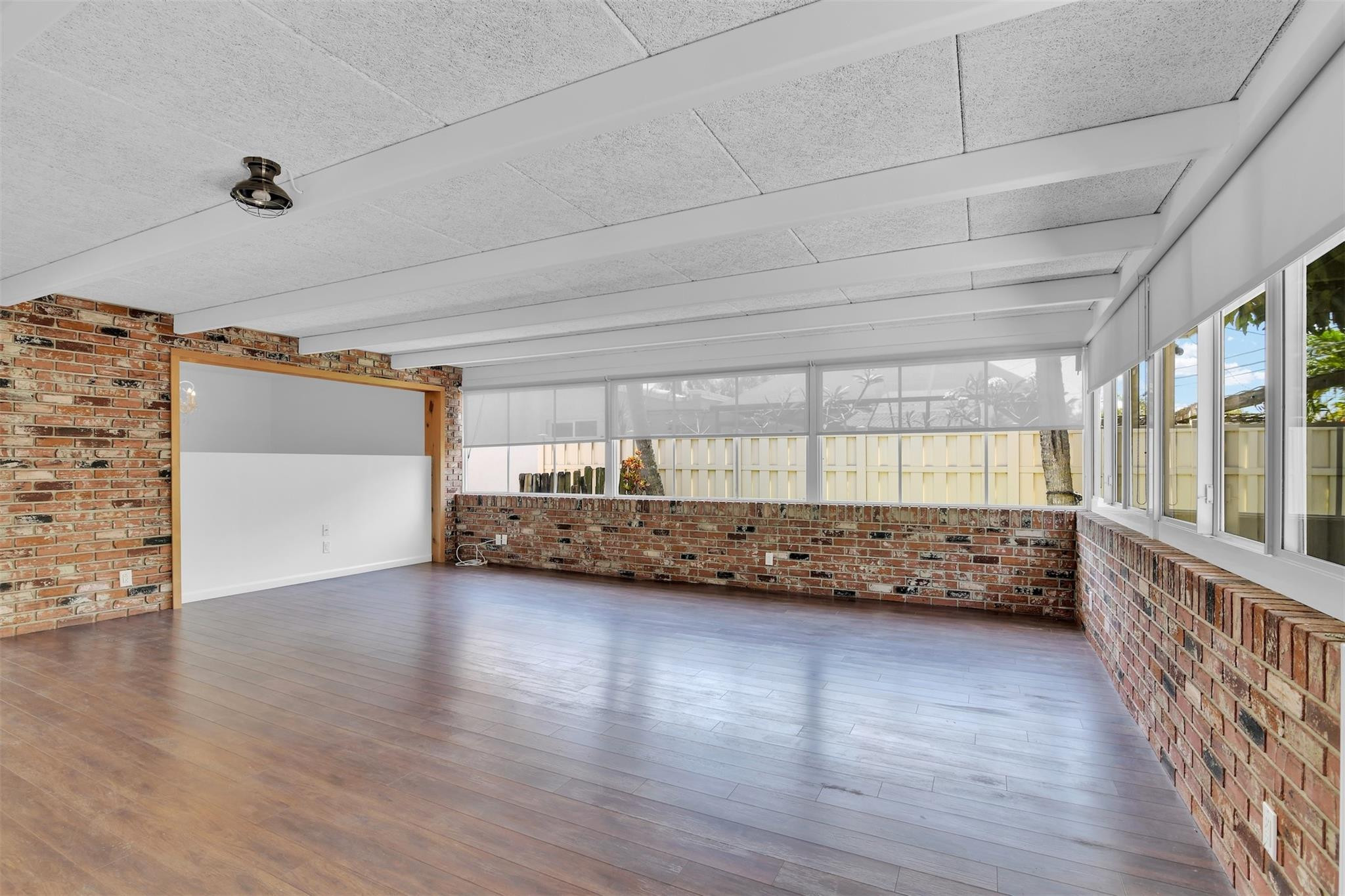 341 Southeast 8th Street Pompano Beach, FL 33060 - Photo 3 of 56 a view of an empty room with wooden floor and a window