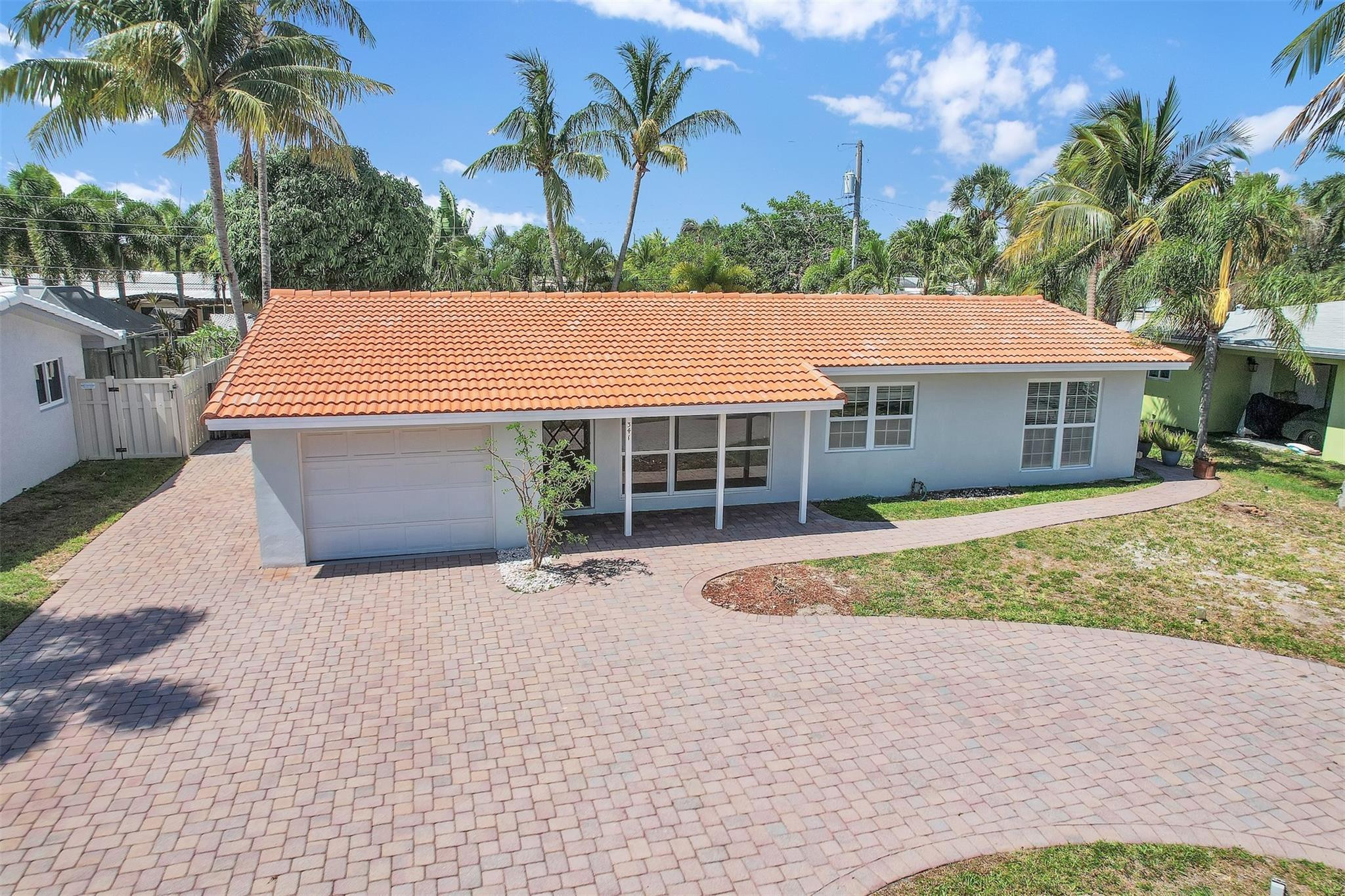 341 Southeast 8th Street Pompano Beach, FL 33060 - Photo 32 of 56 a front view of a house with a garden and trees