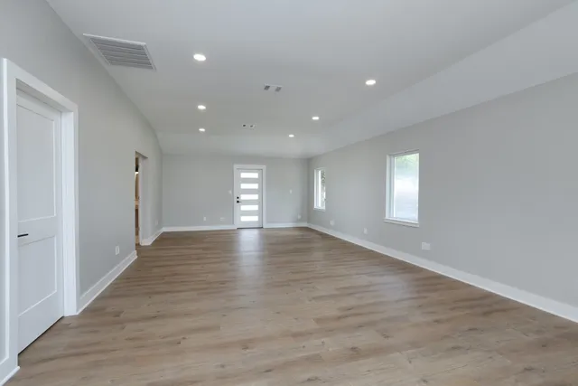 a view of empty room with window and wooden floor