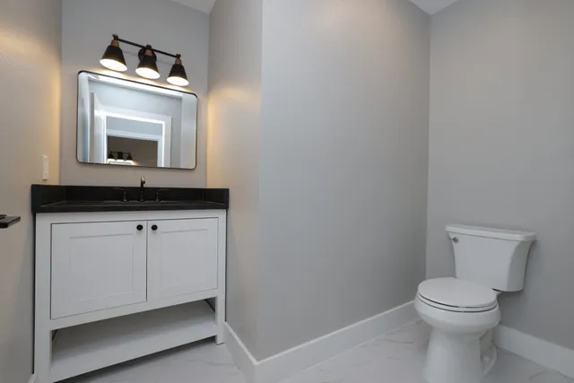 a bathroom with a toilet sink and mirror