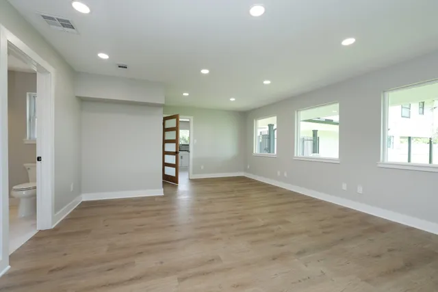 an empty room with wooden floor and windows