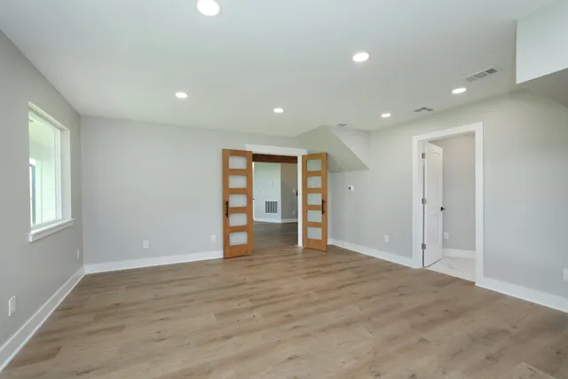 an empty room with closet and windows
