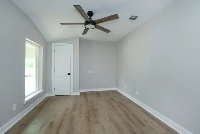 a view of a big room with wooden floor closet and windows