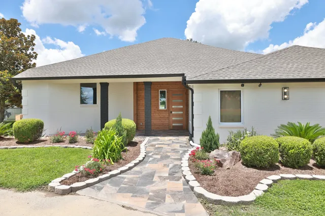 a front view of a house with a yard and potted plants