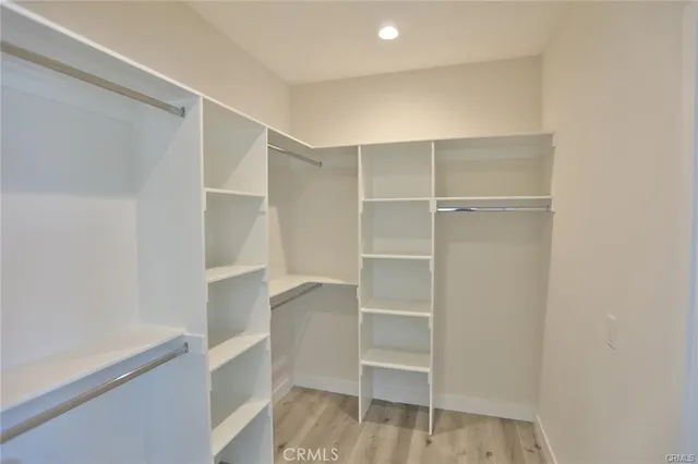 a view of walk in closet with empty racks