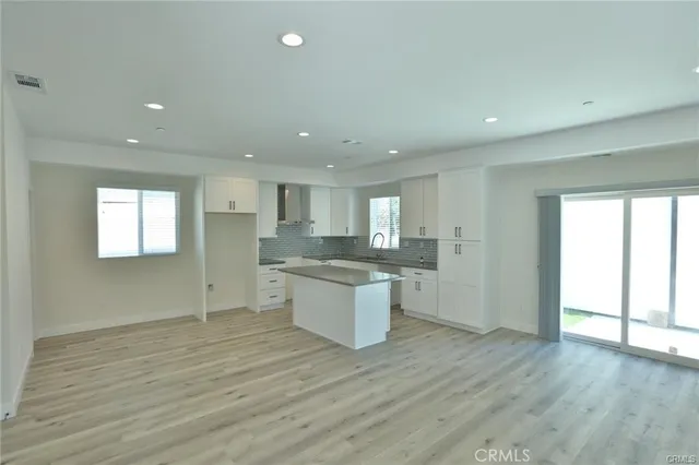 a large kitchen with a wooden floor and window