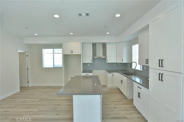 a large kitchen with stainless steel appliances kitchen island granite countertop a large counter top and a sink