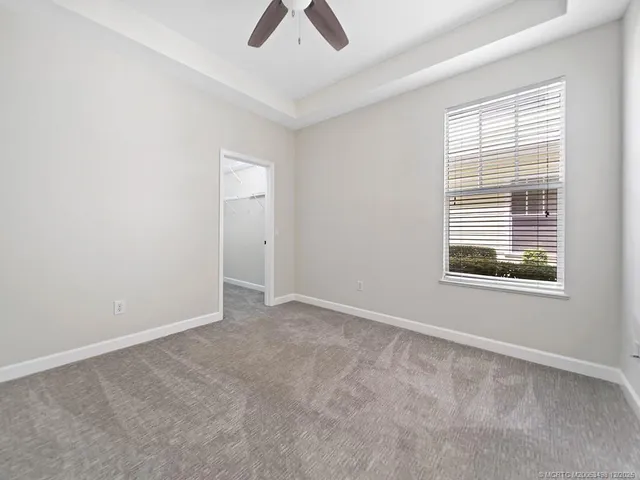an empty room with fan and windows