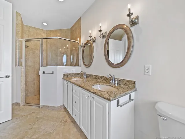 a bathroom with a granite countertop sink a mirror and a shower