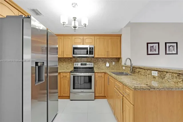 a kitchen with stainless steel appliances granite countertop a sink stove and refrigerator