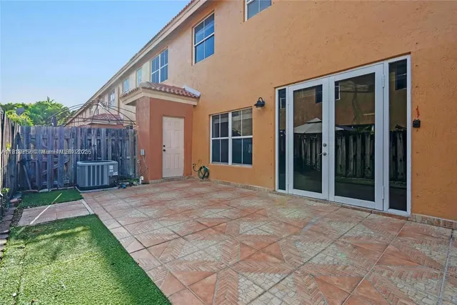 a view of a house with backyard and wooden fence