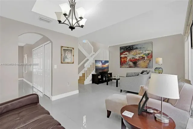 a living room with furniture and a chandelier