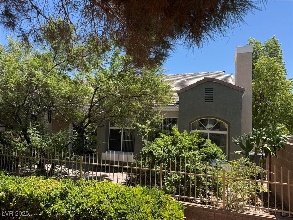 985 Prestwick Street Las Vegas, NV 89145 - Photo 11 of 27 Rear view of house with a tile roof, stucco siding, and a chimney