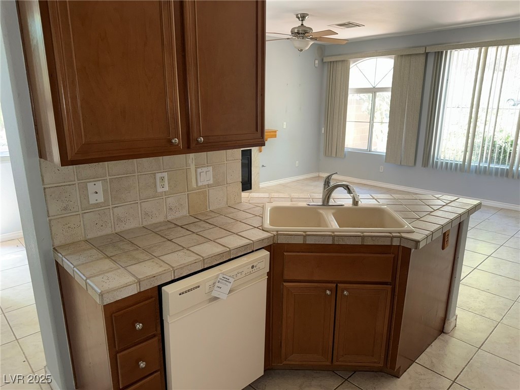 985 Prestwick Street Las Vegas, NV 89145 - Photo 22 of 27 Kitchen featuring light tile patterned floors, plenty of natural light, and white dishwasher