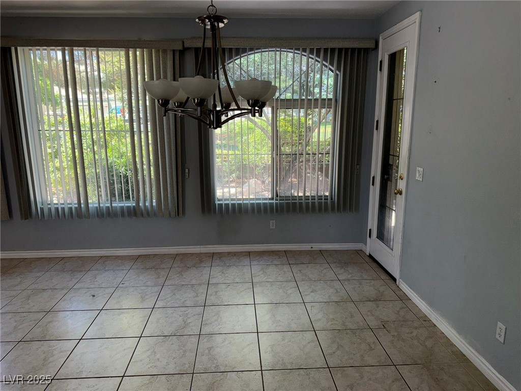 985 Prestwick Street Las Vegas, NV 89145 - Photo 23 of 27 Unfurnished dining area with a chandelier and tile patterned floors