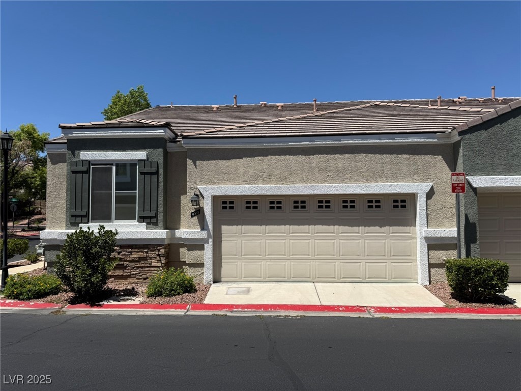 985 Prestwick Street Las Vegas, NV 89145 - Photo 3 of 27 Single story home with a tile roof, stucco siding, and a garage