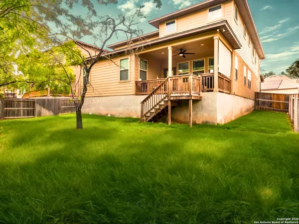 a view of a house with backyard and a tree