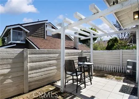 a view of a patio with table and chairs with wooden fence and plants