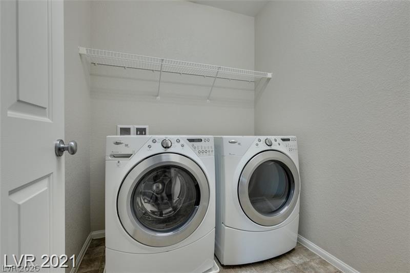 5475 Ordesa Valley Road Las Vegas, NV 89148 - Photo 15 of 35 Functional laundry space featuring modern appliances and convenient overhead storage.