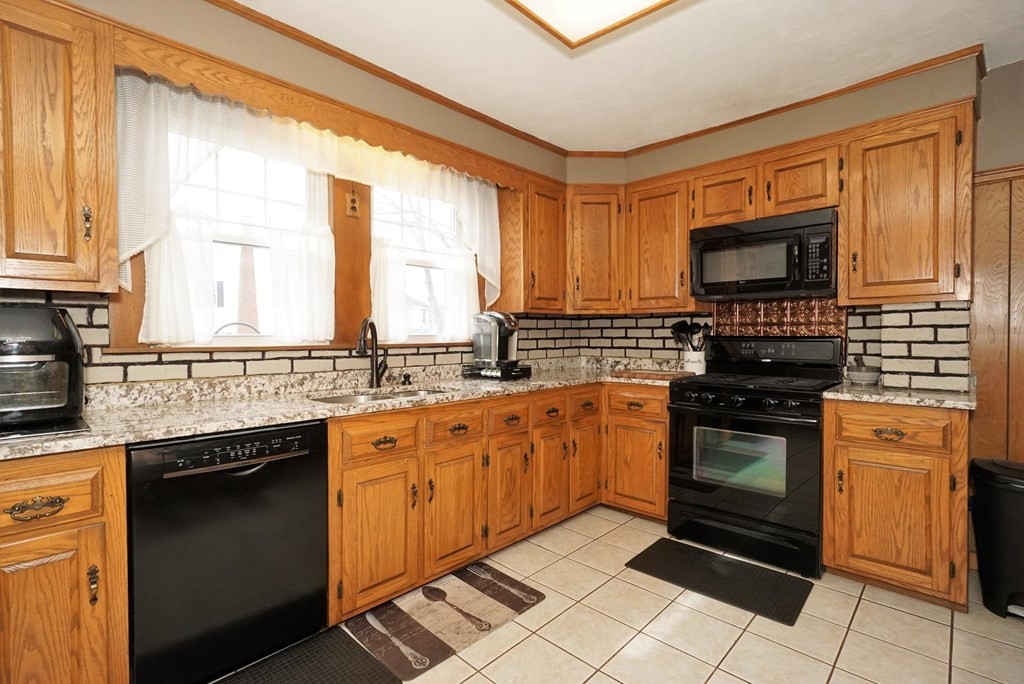 14 East Prospect Street Methuen, MA 01844 - Photo 24 of 42 a kitchen with stainless steel appliances granite countertop a stove sink and cabinets