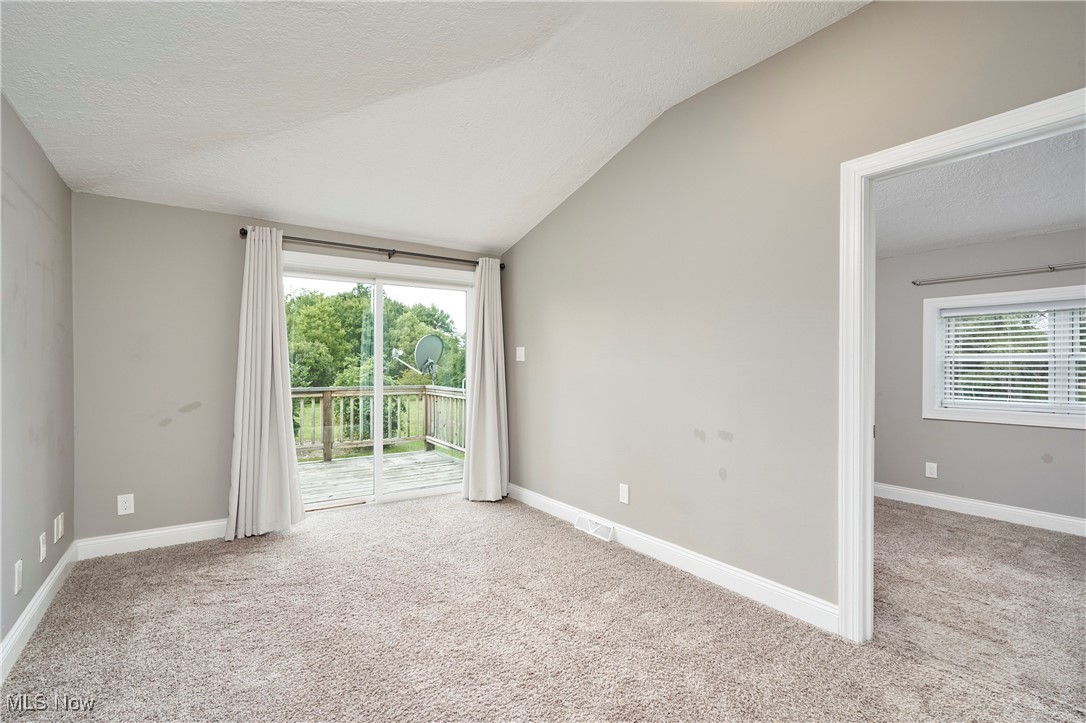 4226 Broadview Road Richfield, OH 44286 - Photo 13 of 24 Unfurnished room featuring light colored carpet, lofted ceiling, and a textured ceiling