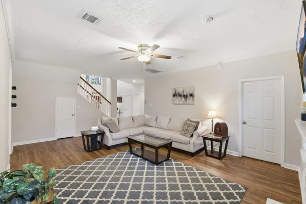 a living room with furniture and wooden floor