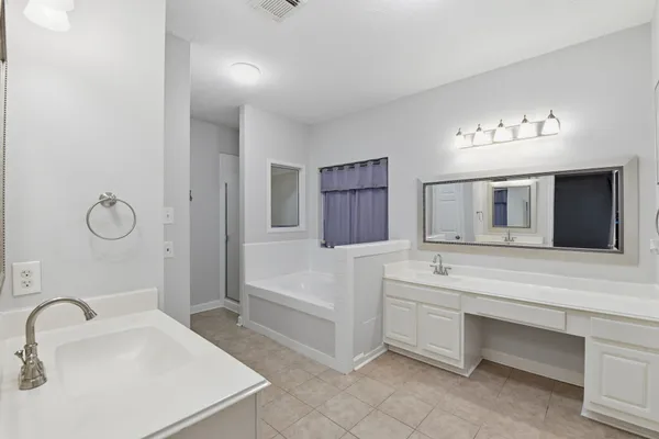 a bathroom with a sink tub and a mirror