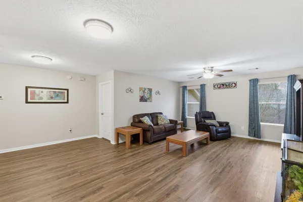 a living room with furniture and a wooden floor
