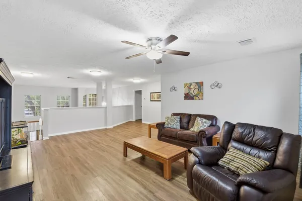 a living room with furniture and a wooden floor