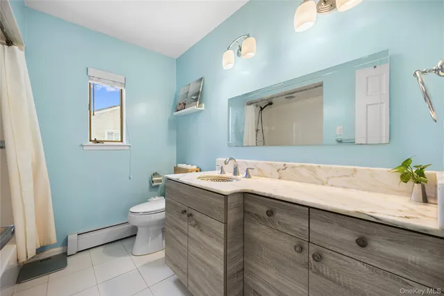 a bathroom with a granite countertop sink mirror vanity and toilet