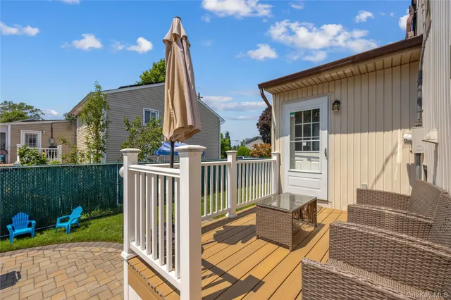 a view of a house with wooden deck and furniture