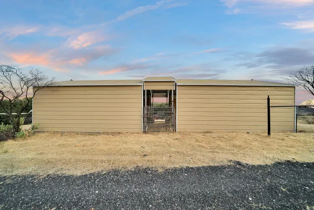 a view of a chairs and table in the back of a building