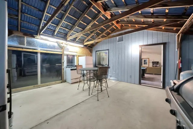 a view of a backyard with large trees and wooden fence