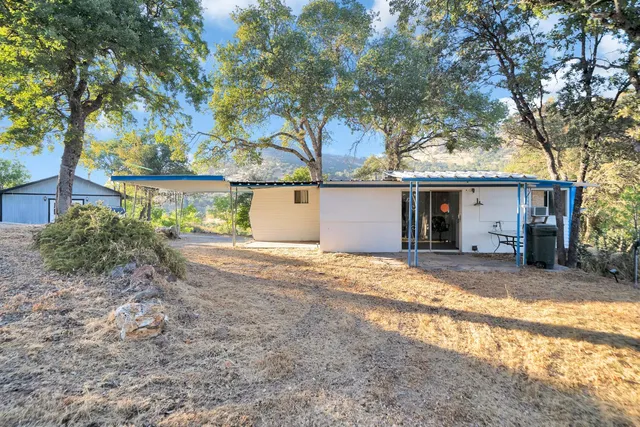 a living room with furniture kitchen view and a chandelier