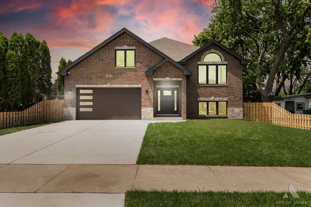a front view of a house with a yard and trees