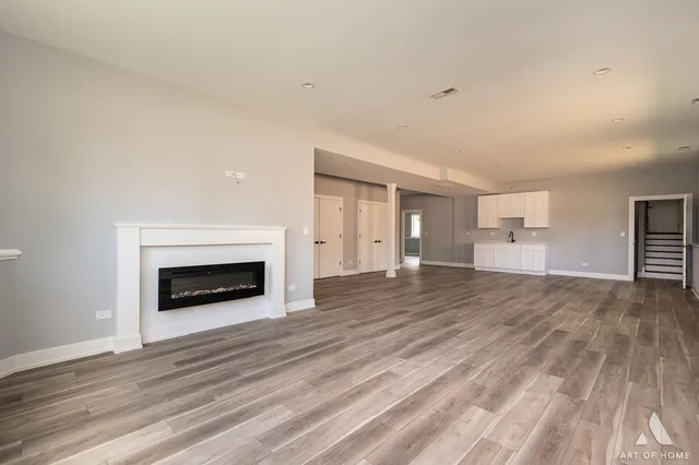 a kitchen with stainless steel appliances granite countertop a sink a stove and a wooden floors