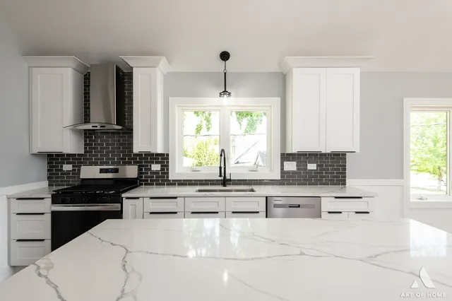 a kitchen with kitchen island granite countertop a sink stove and refrigerator