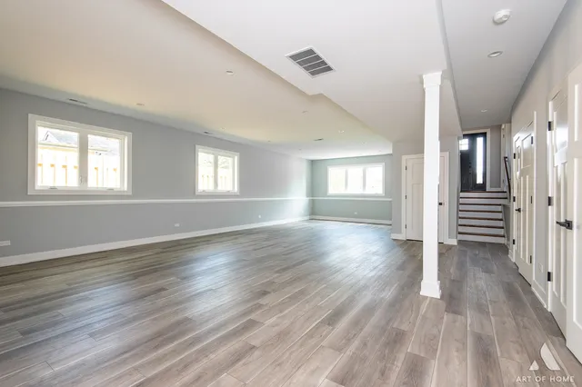 a view of empty room with wooden floor and window