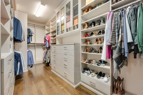 a view of walk in closet with clothes and shoes