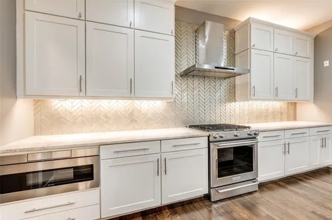 a kitchen with granite countertop white cabinets and white appliances