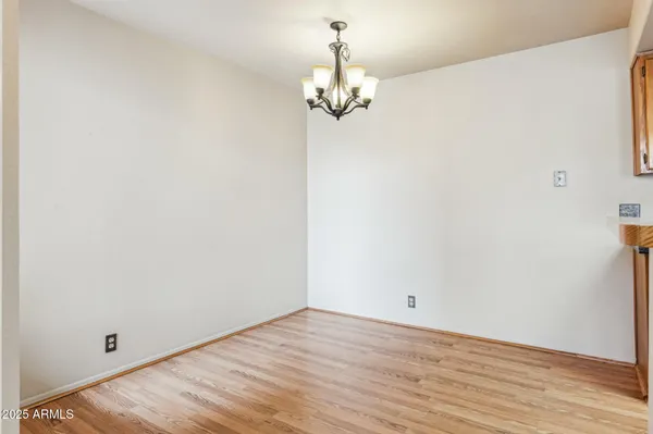 a view of a room with wooden floor and chandelier