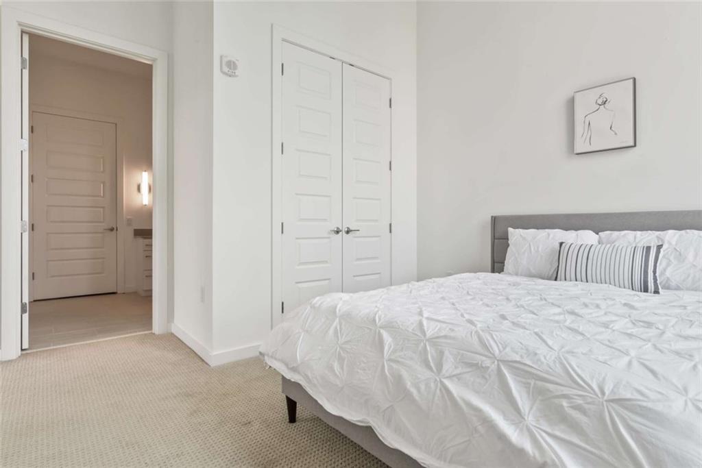 205 12th Street Northeast, Unit 3 Atlanta, GA 30309 - Photo 11 of 24 a bedroom with a bed and cabinets