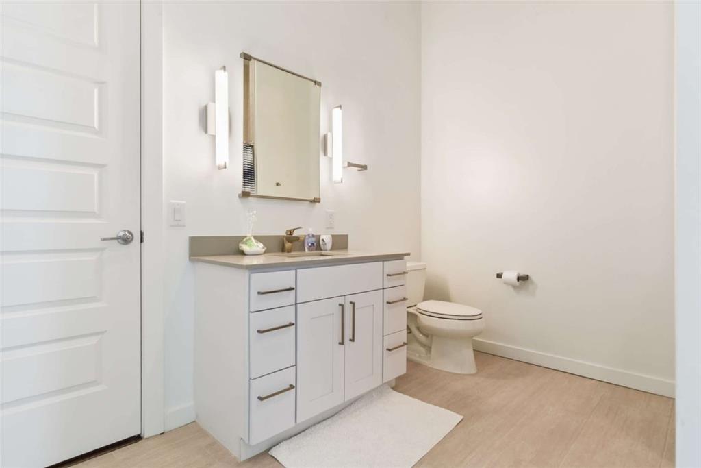 205 12th Street Northeast, Unit 3 Atlanta, GA 30309 - Photo 12 of 24 a bathroom with a granite countertop sink toilet and mirror