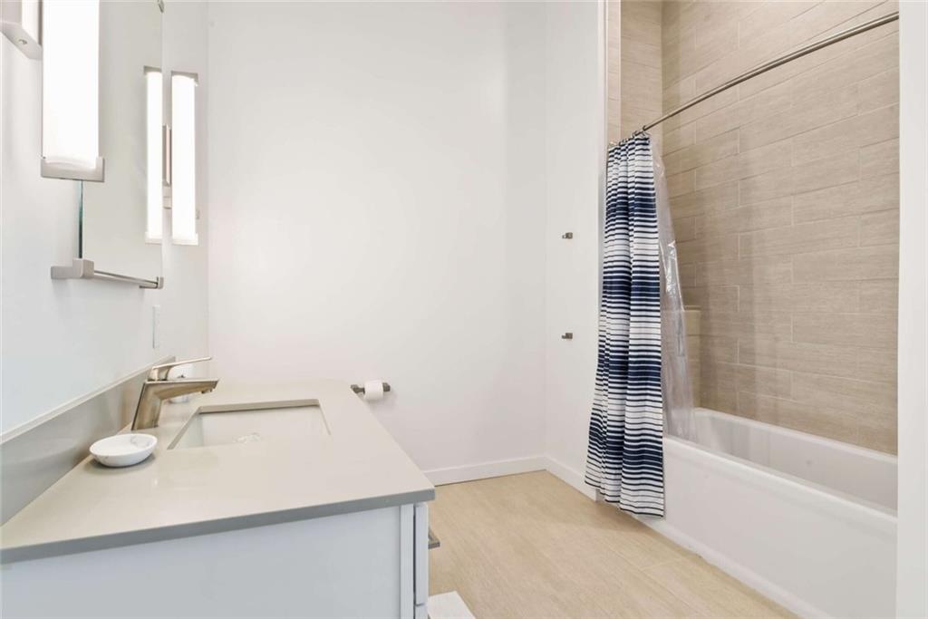 205 12th Street Northeast, Unit 3 Atlanta, GA 30309 - Photo 13 of 24 a bathroom with a sink and a mirror