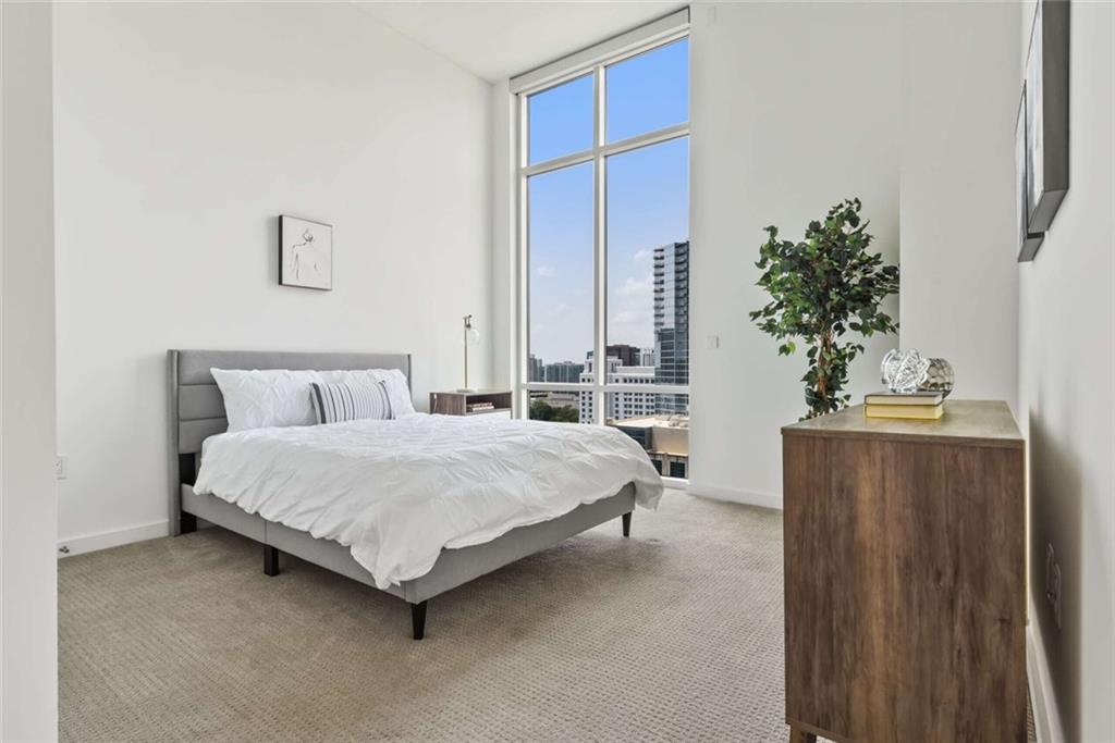 205 12th Street Northeast, Unit 3 Atlanta, GA 30309 - Photo 10 of 24 a bedroom with a bed table and a potted plant