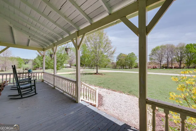 a view of a dining room and livingroom with furniture wooden floor a chandelier